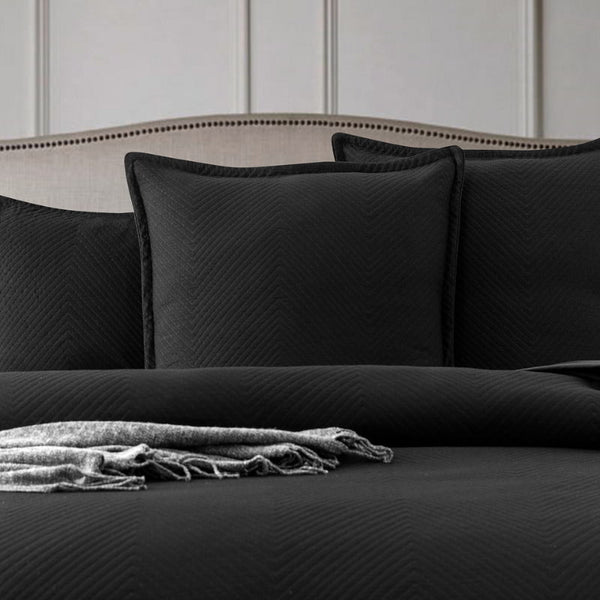 alt="A european pillowcase featuring an embossed design with a sham edge deep black in a cosy bedroom"
