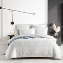 alt="Showcasing an ivory quilt cover set infused with blooming flower bundles"