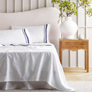 Opulent Renee Taylor Cloud Sheet Set featuring 1000-thread count Egyptian cotton, available in white with chic navy edges.