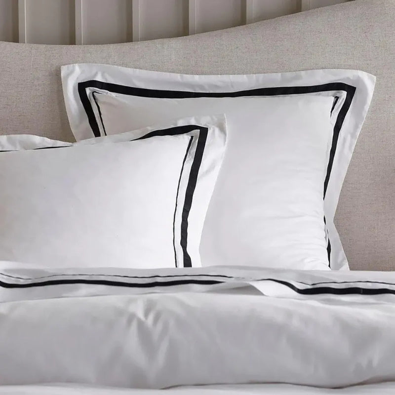 Zoom in details of the luxurious Renee Taylor Cloud Quilt Cover Set in white and charcoal, crafted from 1000-thread count Egyptian cotton for ultimate comfort.