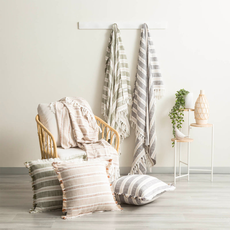 Renee Taylor Como Juniper throw styled on rattan armchair with matching cushions

