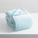 A sumptuous blue colour velvet blanket, meticulously folded on a pristine white surface, showcasing a refined diamond pattern and flawless edges.