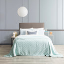 A cozy bedroom featuring blue ultra soft velvet blanket with a diamond pattern and clean edge.