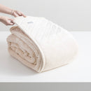 Exquisite stone velvet blanket featuring a diamond pattern, gracefully displayed on a table.