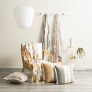 Sage striped throw styled on a rattan chair with matching cushions and wall-hung throws

