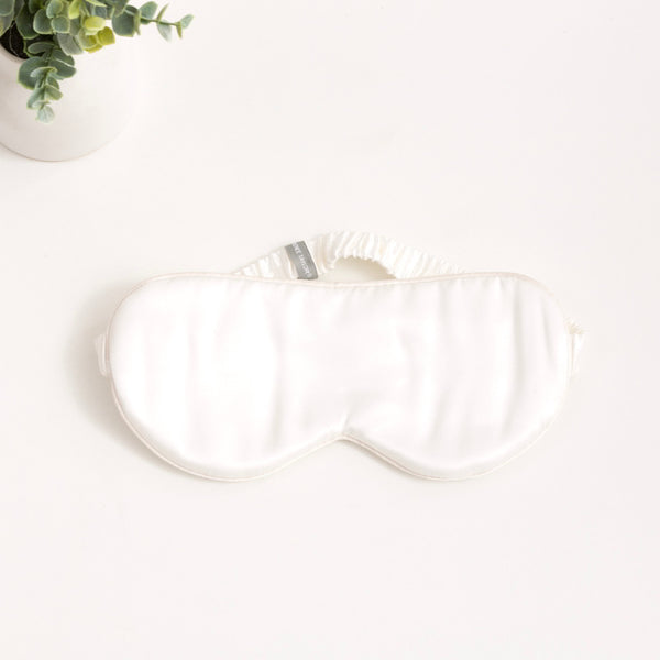 alt="White silk eye mask with 6 layers of soft padding, made from 100% pure mulberry silk. Gentle on skin, prevents wrinkles, and hydrates."