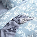 A sophisticated blue and white bed adorned with a stylish leaf print, creating a tranquil atmosphere.