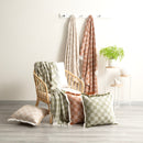 Neutral checkered throw with fringe detail draped over a timber chair alongside matching cushions.
