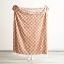 Person holding the Renee Taylor terracotta checkered throw at full size

