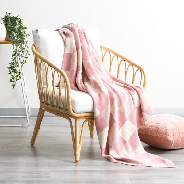 alt="Pink and white checkered throw made of high-quality cotton knit. Large checks add sophistication, soft hand-feel brings warmth and comfort."