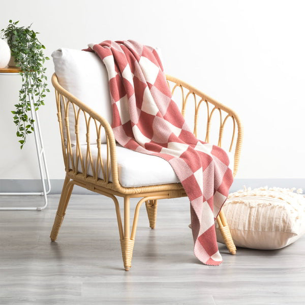alt="A meticulously crafted rust and white blanket with captivating large checks design, made of high-quality cotton knit for durability and comfort."