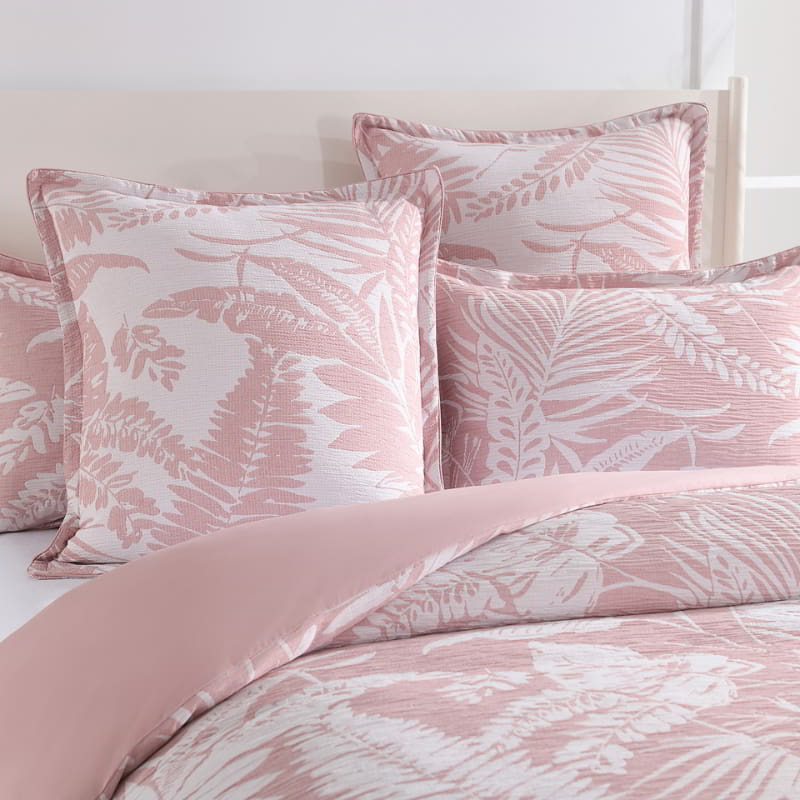 alt="Showcasing a shade of pink european pillowcase featuring intricate island themes with swaying palm trees in tropical rainforest in a cosy bedroom"