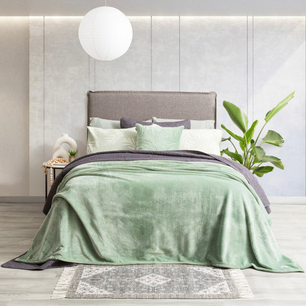 Lavish bed adorned with a pristine eucalyptus ultra soft velvet blanket and generously oversized.