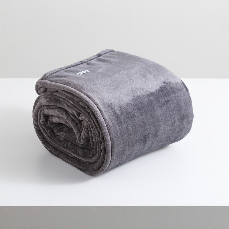 A sumptuous, generously-sized, graphite ultra-soft velvet blanket, elegantly folded on a pristine white surface.