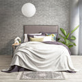 Lavish bed adorned with a pristine silver line color ultra soft velvet blanket and generously oversized.