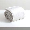 A sumptuous, generously-sized, ultra-soft  silver line colour velvet blanket, elegantly folded on a pristine white surface.