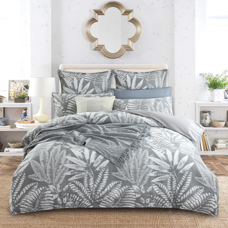 alt="A luxurious, eclectic mix of modern and conventional design bedding set that creates a tropical retreat with lush leaves."