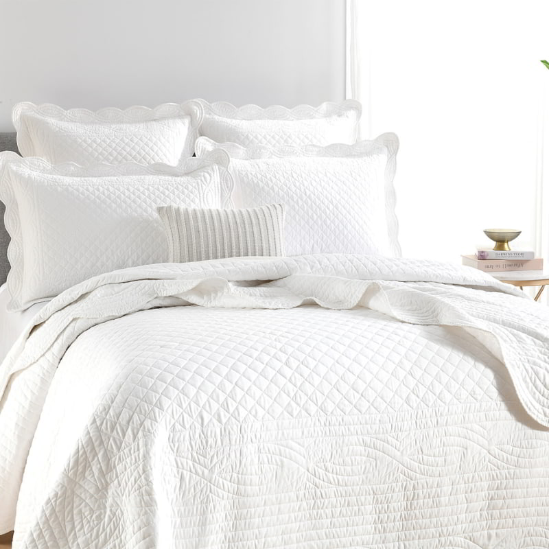 alt="Showcasing a shade of white european pillowcase with a nod to French quilting tradition and decorative details like scallop edges in a luxurious bedroom."