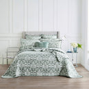 alt="Showcasing elegant coverlet boasting a timeless jade and white damask pattern, highlighted by sharp, straight piped edge detailing in a luxurious bedroom."