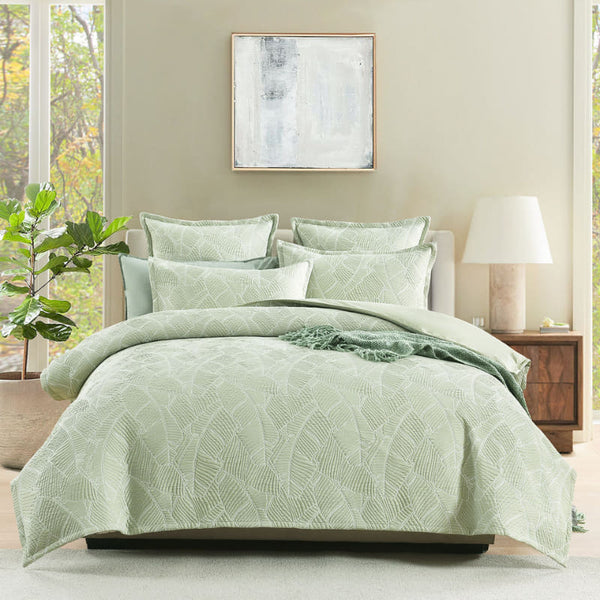 Full bed view of quilt cover set layered with matching pillows in a light-filled room