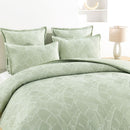 Renee Taylor Woods sage jacquard quilt cover styled on a bed with matching pillowcases