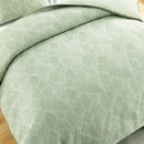 Side detail showing the woven texture and curved quilting pattern on the duvet