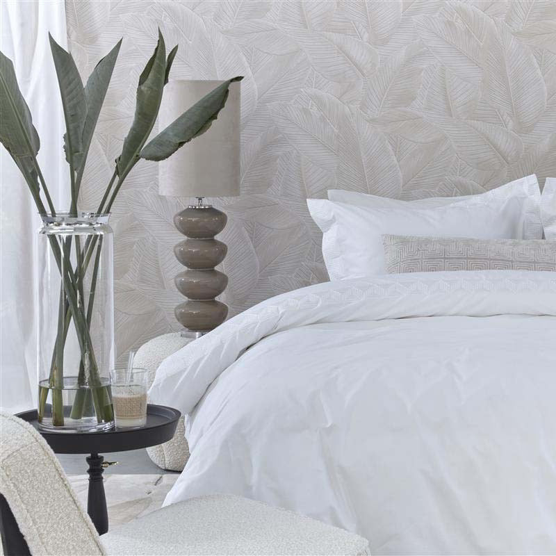 alt="A sophisticated white quilt cover set featuring a narrow horizontal band with embroidered geometric pattern"