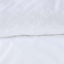 alt="Close-up look of a sophisticated white quilt cover set featuring a narrow horizontal band with embroidered geometric pattern"