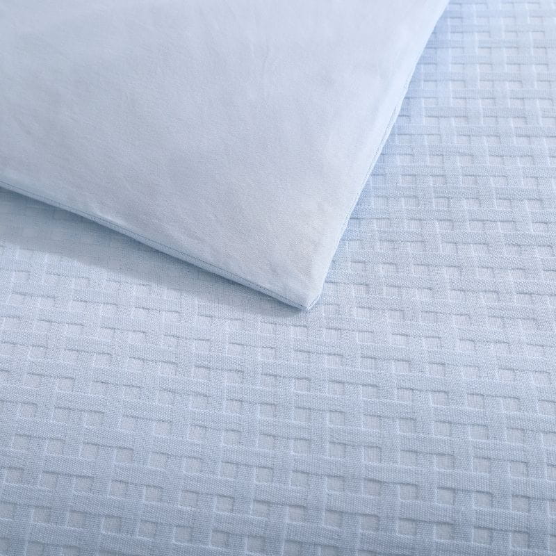 Detailed shot of a blue quilt cover set from Tommy Bahama creates a serene oasis for your bedroom. 