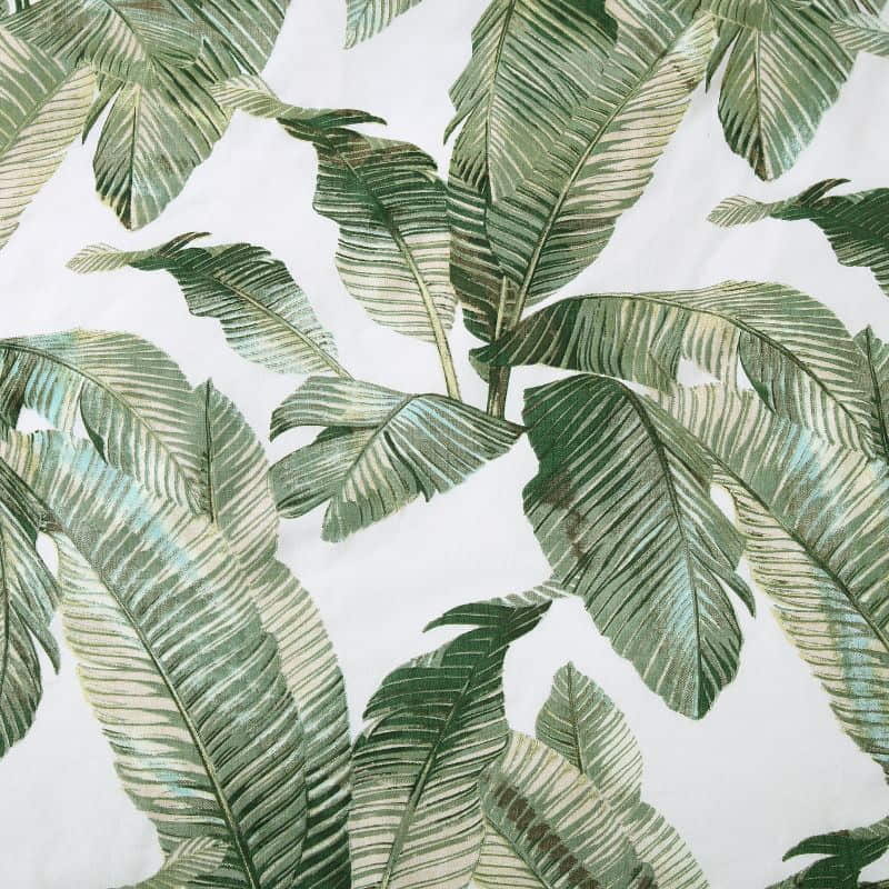 Detailed shot of a luxurious tropical print bedding set with palm leaves, perfect for a peaceful and comfortable siesta. 