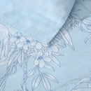 Zoom in angle of bed with tropical print quilt cover