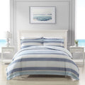 A serene bedroom with a soft blue striped quilt cover set, creating a calming atmosphere for sweet dreams.