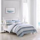 Side view of a serene bedroom with a soft blue striped quilt cover set, creating a calming atmosphere for sweet dreams.