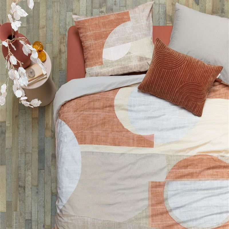 alt="High-quality cotton quilt cover with a modern graphic print in natural and terracotta colours. The printed linen texture on the background adds depth to the design, while the reverse side is a solid sand colour."