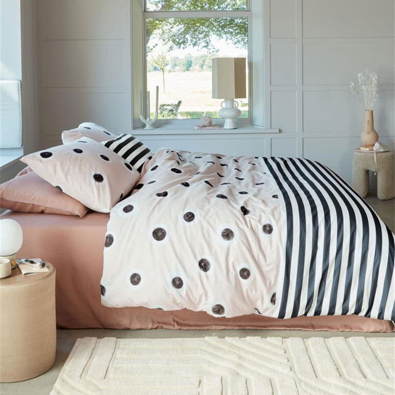 alt="Dotted and striped quilt cover with hand-painted black and white dots on a cream background on the top side and horizontal black and white stripes on the underside"
