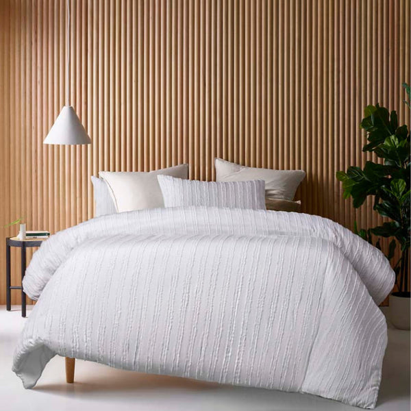 alt="A white quilt cover set featuring chenille stripes and minimalistic style on a cosy bedroom"