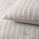 alt="Zoom in details of a natural comforter set featuring chenille stripes design and adding minimalistic style on a cosy bedroom along with the pillowcases"