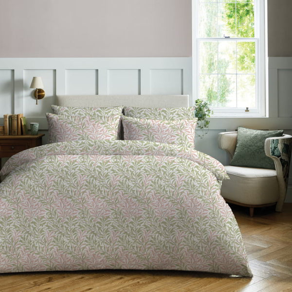 William Morris At Home Willow Bough Summer Quilt Cover Set featuring a delicate green leaf pattern on a crisp white background, styled in a sunlit bedroom.