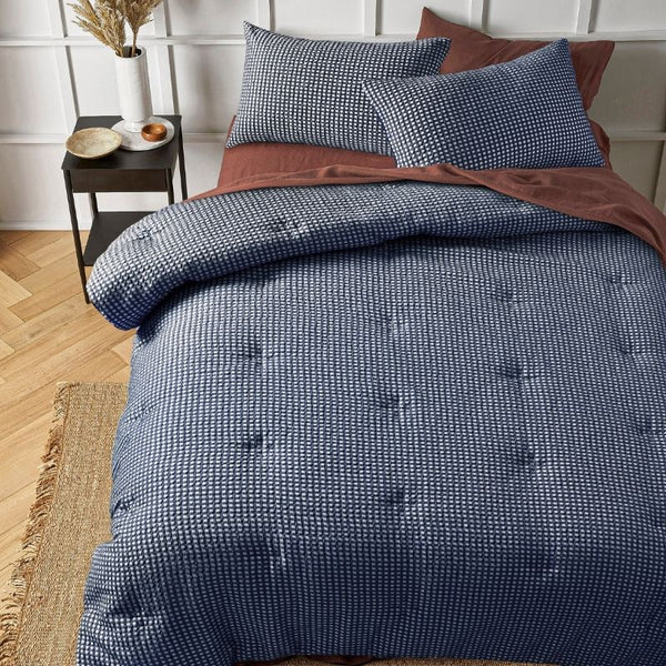 Navy waffle comforter set styled on bed with matching pillowcases.