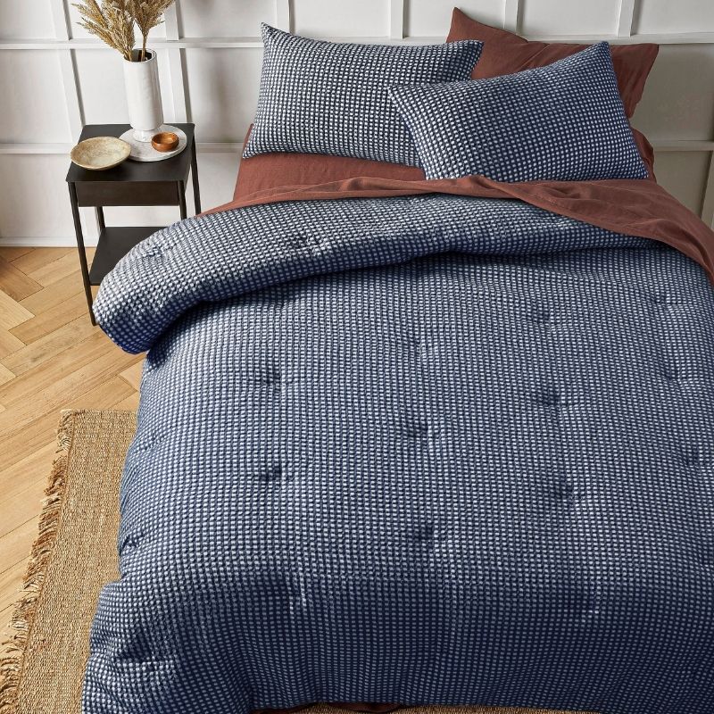 Navy waffle comforter set styled on bed with matching pillowcases.