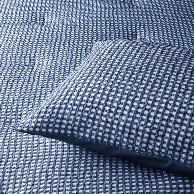 Navy waffle comforter set styled on bed with matching pillowcases.