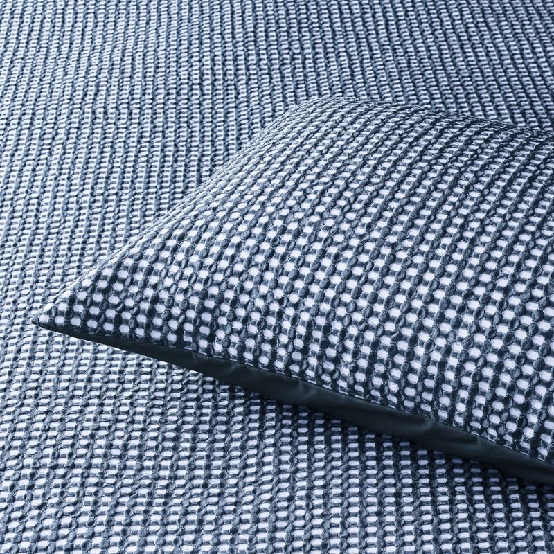 Navy waffle quilt cover set styled with matching pillowcases on a bed.
