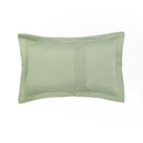 Lightweight sage coverlet set paired with neutral cushions on a timber bedside.