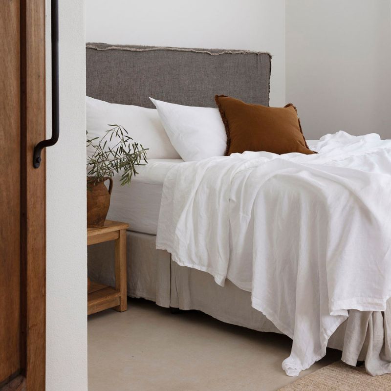Close-up of white French linen sheets showing soft, relaxed texture.