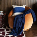 Close-up of the knitted texture and square pattern on the navy throw.