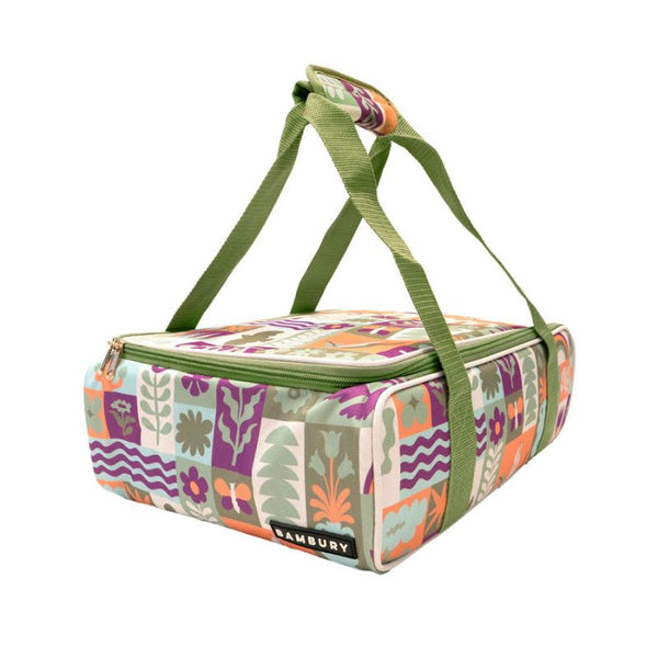 Colorful insulated lunch bag with floral pattern and green straps on a white background