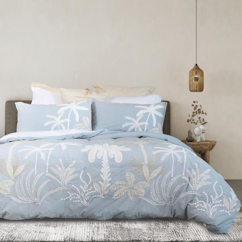 Light blue embroidered quilt cover set with matching pillowcases and natural décor