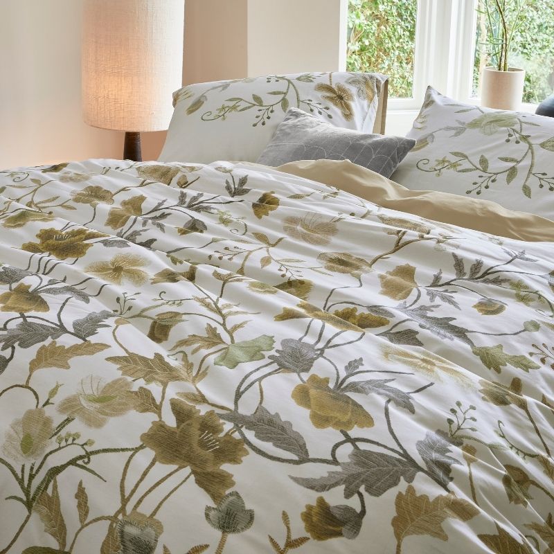 Nature-inspired floral quilt cover styled in a bright bedroom.