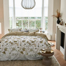 Nature-inspired floral quilt cover styled in a bright bedroom.