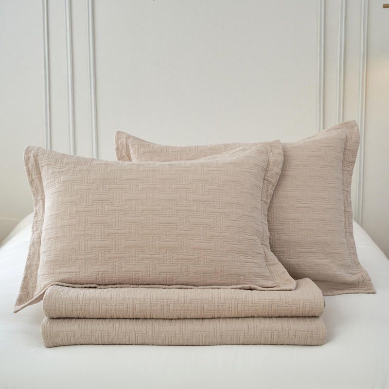 Lightweight cotton coverlet draped neatly over a bed, creating a calm, inviting look.